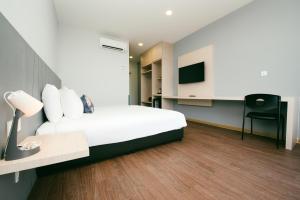 a hotel room with a bed and a tv at Signature by The Concept in Kuah