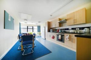 a large kitchen with a table and chairs in it at Bonington Student Village (Campus Accommodation) in Sutton Bonington