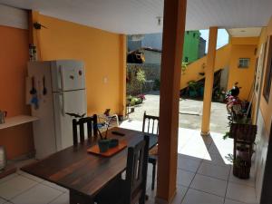 een keuken met een houten tafel en een koelkast bij Guest House Palmeiras in Cabo Frio