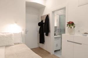 een witte badkamer met een bed en een wastafel bij Studio Apartment Gea Tour As Ljubljana in Ljubljana