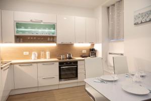 een keuken met witte kasten en een wit aanrecht bij Studio Apartment Gea Tour As Ljubljana in Ljubljana