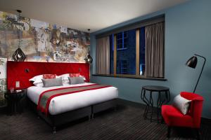 a bedroom with a red bed and a red chair at Malmaison Edinburgh City in Edinburgh