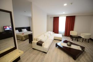 a living room with a white couch and a mirror at Arsan Otel in Kahramanmaraş