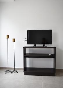 una TV a schermo piatto seduta sopra un centro di intrattenimento nero di Complejo Las Rosas a Rafaela