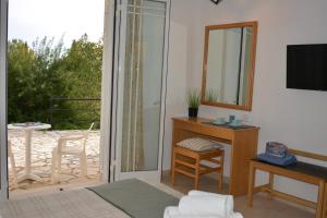 a living room with a mirror and a desk and a balcony at Elite Corfu - Adults Friendly in Kommeno