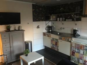 cocina con encimera, fregadero y mesa en B&B Zonnedauw en Zwartemeer