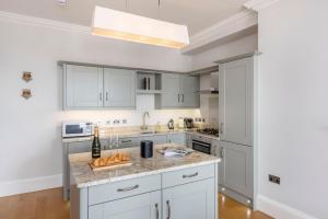 een keuken met witte kasten en een aanrechtblad bij Brunswick Place in Bath