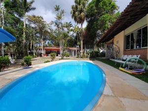 a large blue swimming pool next to a house at Pousada de serra TUTUCA in Guaramiranga