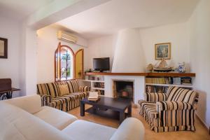 sala de estar con 2 sofás y chimenea en Villa Mumare, en Cala d´Or