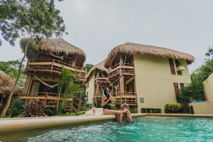 two women sitting in the swimming pool at a resort at Hotel Carolina Bacalar in Bacalar