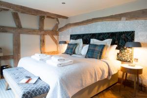 a bedroom with a large bed with towels on it at The Legh Arms Prestbury in Macclesfield