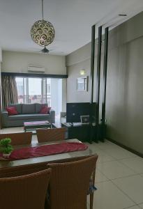 a living room with a table and a couch at CT Homestay at Lagoon Park Resort in Melaka