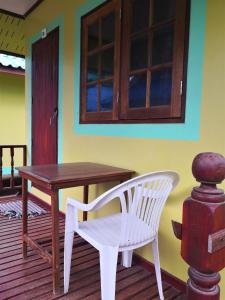 a wooden table and a white chair on a porch at Mama O Chai Koh Tao in Koh Tao +90 photos