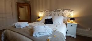 a bedroom with a white bed with towels on it at Suite EDEN avec jacuzzi privé in Chaumont
