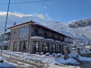 a building in the snow in front of a mountain at Lilea's Castle in Lílaia