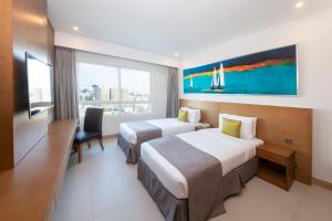 A bed or beds in a room at Ramada by Wyndham Beach Hotel Ajman