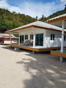 a house on the beach with a table at Bottle Beach 2 Bungalows in Bottle Beach