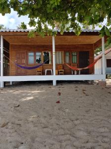 a house with a hammock in front of it at Bottle Beach 2 Bungalows in Bottle Beach