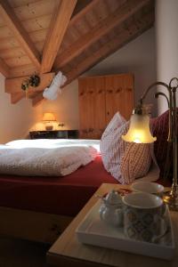 a bedroom with a bed and a table with a lamp at B&B Casa Riz in Castello di Fiemme