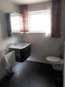La salle de bains est pourvue d'un lavabo, de toilettes et d'une fenêtre. dans l'établissement Ferienwohnung Schehl, à Erlenbach
