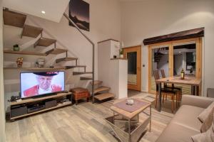 a living room with a flat screen tv and stairs at Chalet Abacus in Zermatt