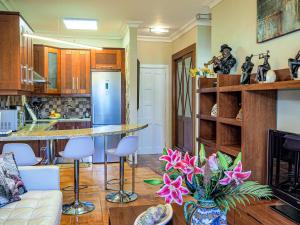 cocina y sala de estar con mesa y sillas en Perfect Apartment, en Puerto de la Cruz