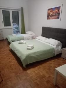 ローマにあるOlimpica Relais guest house CIR 28624のベッドルーム1室(ベッド2台、タオル付)