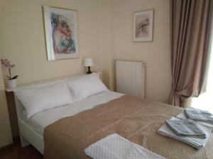 a bedroom with a bed with two towels on it at Rozy House Nei Epivates Thessaloniki ( Near the sea) in Neoi Epivates