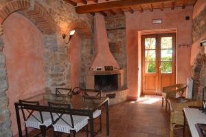 カステッリーナ・イン・キアンティにあるAgriturismo Cignanbiancoの石造りの暖炉とテーブル付きのリビングルーム