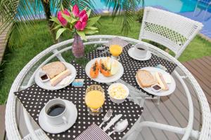 a black and white table with breakfast food on it at Pousada do Frei in Búzios