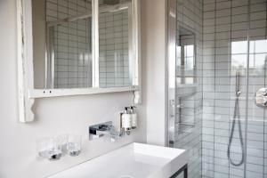 a white bathroom with a sink and a shower at Hertford House in Hertford