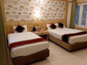 a hotel room with two beds in a room at Hotel Parkland in Sauraha