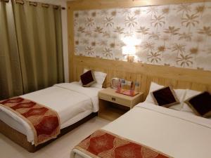 um quarto de hotel com duas camas e uma mesa em Hotel Parkland em Sauraha