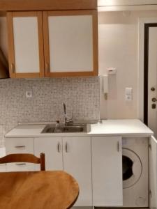 a kitchen with white cabinets and a sink at Rozy House Nei Epivates Thessaloniki ( Near the sea) in Neoi Epivates