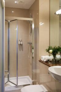 a bathroom with a shower and a toilet and a sink at Hertford House in Hertford