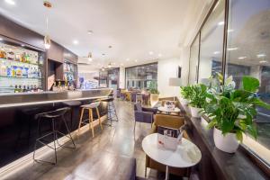 a restaurant with a bar with chairs and plants at Mercure Roma Piazza Bologna in Rome