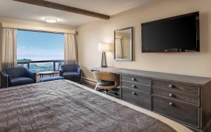 a hotel room with a large bed and a flat screen tv at Gold Beach Inn in Gold Beach