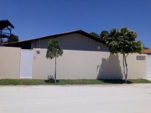 ein weißes Gebäude mit zwei Bäumen davor in der Unterkunft Villa Portal dos Ventos in Fortim