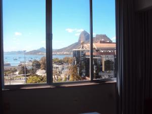 a window with a view of a city and a mountain at Apartamento Botafogo Beach in Rio de Janeiro