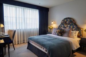 a bedroom with a large bed with a large window at Hertford House in Hertford