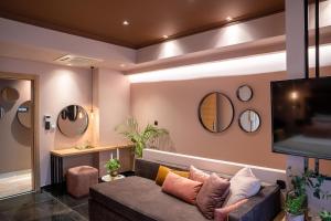 a living room with a couch and a flat screen tv at Olympus Terra Boutique Hotel in Larisa +37 photos