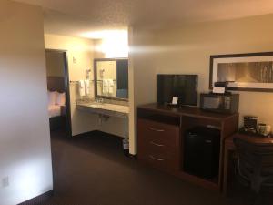 a hotel room with a television and a bathroom at Cobblestone Hotel & Suites - Wisconsin Rapids in Wisconsin Rapids