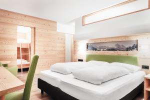 Postel nebo postele na pokoji v ubytování Kristiania Small Dolomites Hotel