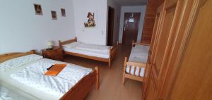 Cette chambre comprend 2 lits et une chaise. dans l'établissement Gasthaus Mösle, à Oberreute