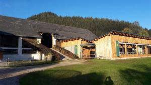 un edificio con un fienile con una montagna sullo sfondo di Schusterbauernhof a Bad Mitterndorf