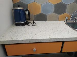 eine Kaffeemaschine auf einer Theke neben einem Waschbecken in der Unterkunft CASA MARGARITA 2Piso Mono Naranja in San Salvador de Jujuy