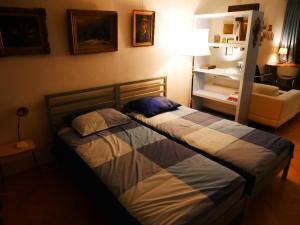 2 camas en un dormitorio con lámpara y sofá en StudioPlus, en Dordrecht