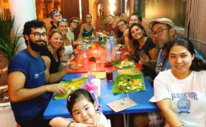 a group of people sitting around a table eating pizza at Ringo's Foyer in Melaka