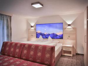 ein Hotelzimmer mit einem Bett und einem Gemälde an der Wand in der Unterkunft Glanzer Homes Hochsölden in Sölden