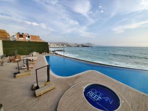 een zwembad met de oceaan op de achtergrond bij Nuevo Condominio en Ocean Reef in San Bartolo